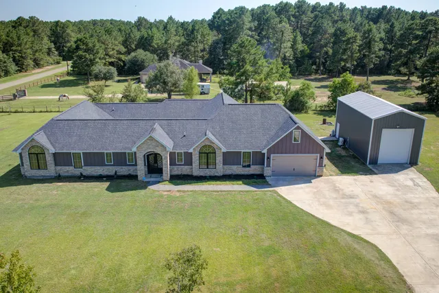 a front view of a house with a yard and trees