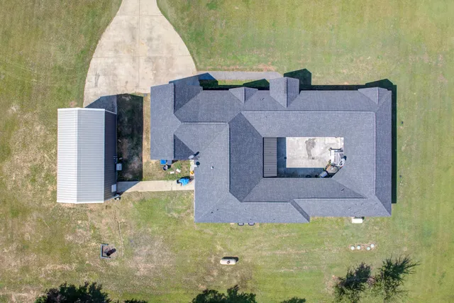 a view of a small yard and large trees