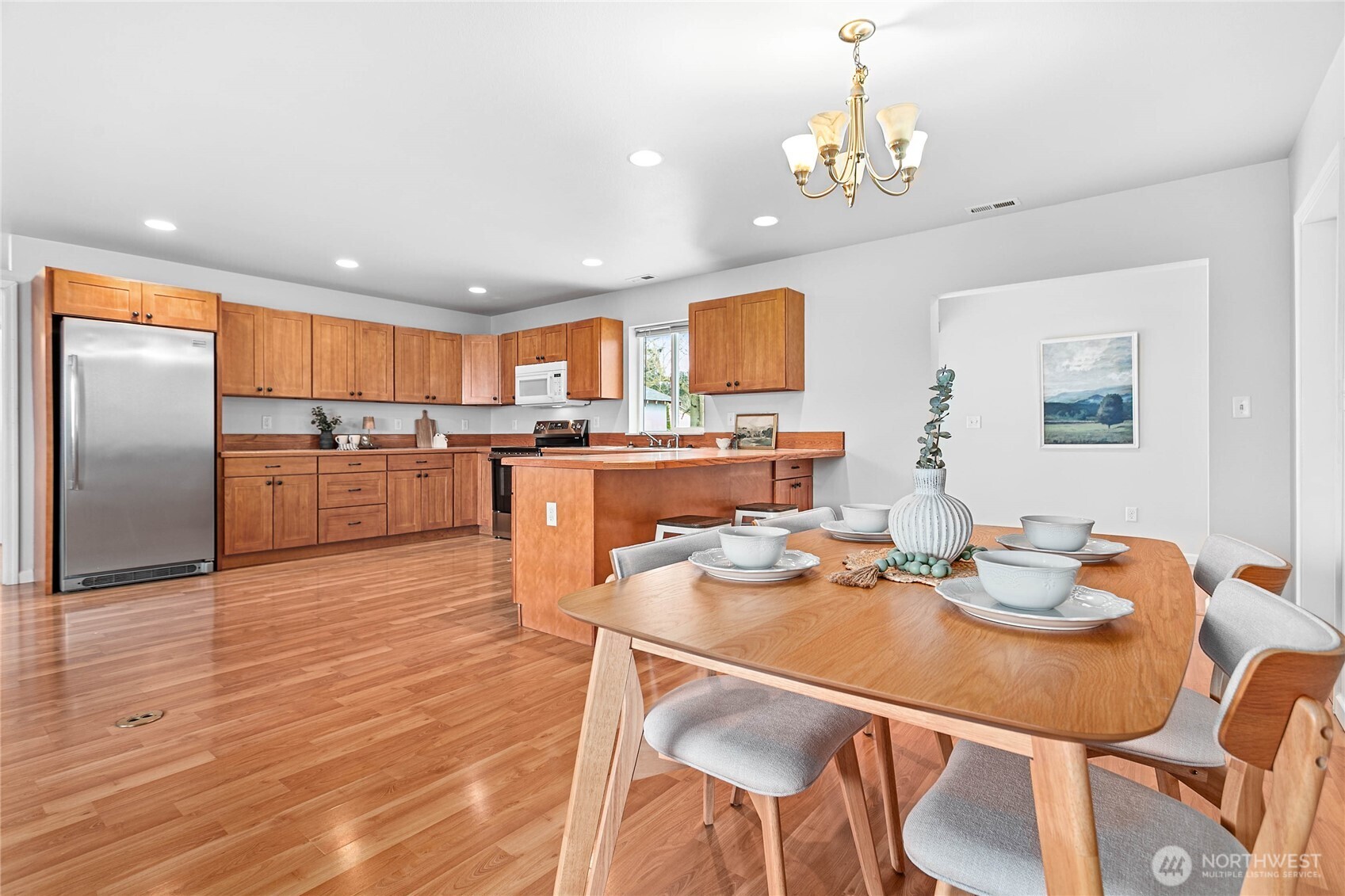 303 Hayes Street Nooksack, WA 98276 - Photo 10 of 40 a open dining room with stainless steel appliances kitchen island granite countertop a table chairs and a refrigerator