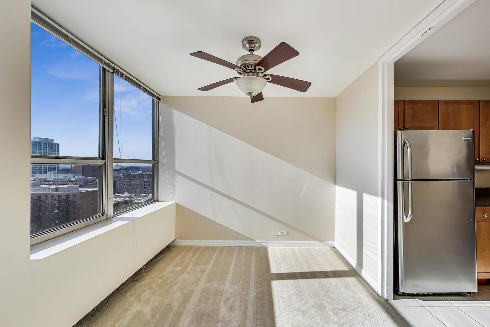655 West Irving Park Road, Unit 1403 Chicago, IL 60613 - Photo 13 of 36 a view of a living room with a ceiling fan and a window