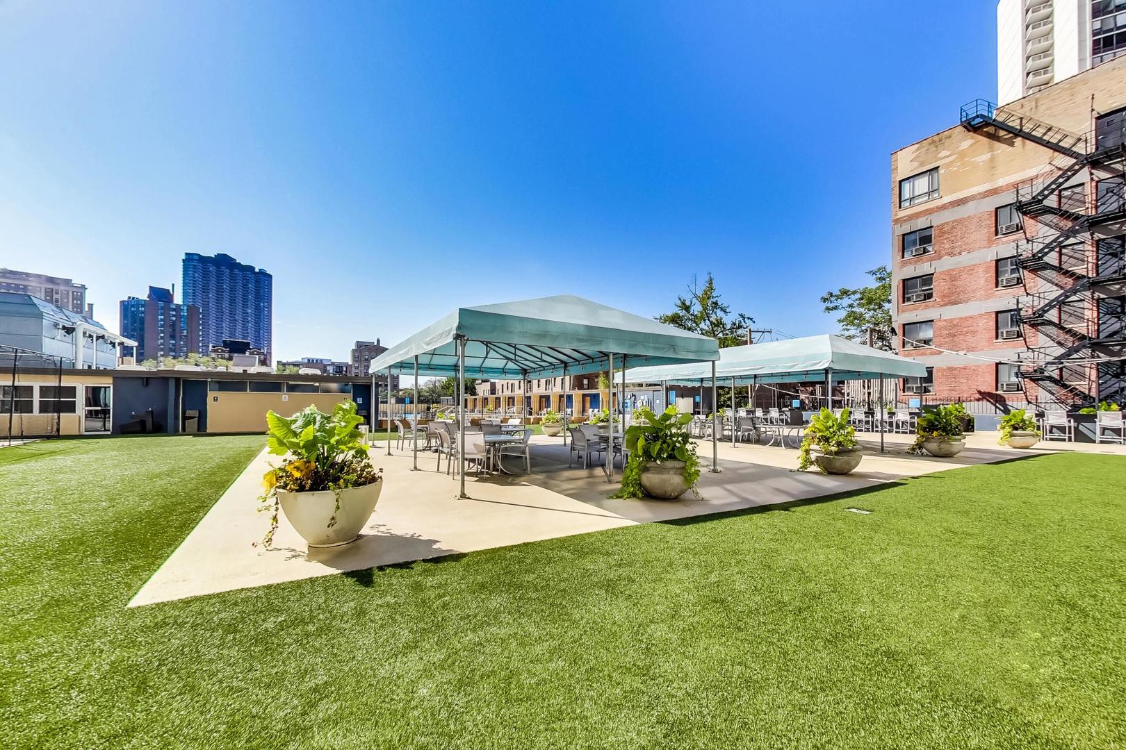 655 West Irving Park Road, Unit 1403 Chicago, IL 60613 - Photo 28 of 36 a view of a patio with table and chairs under an umbrella