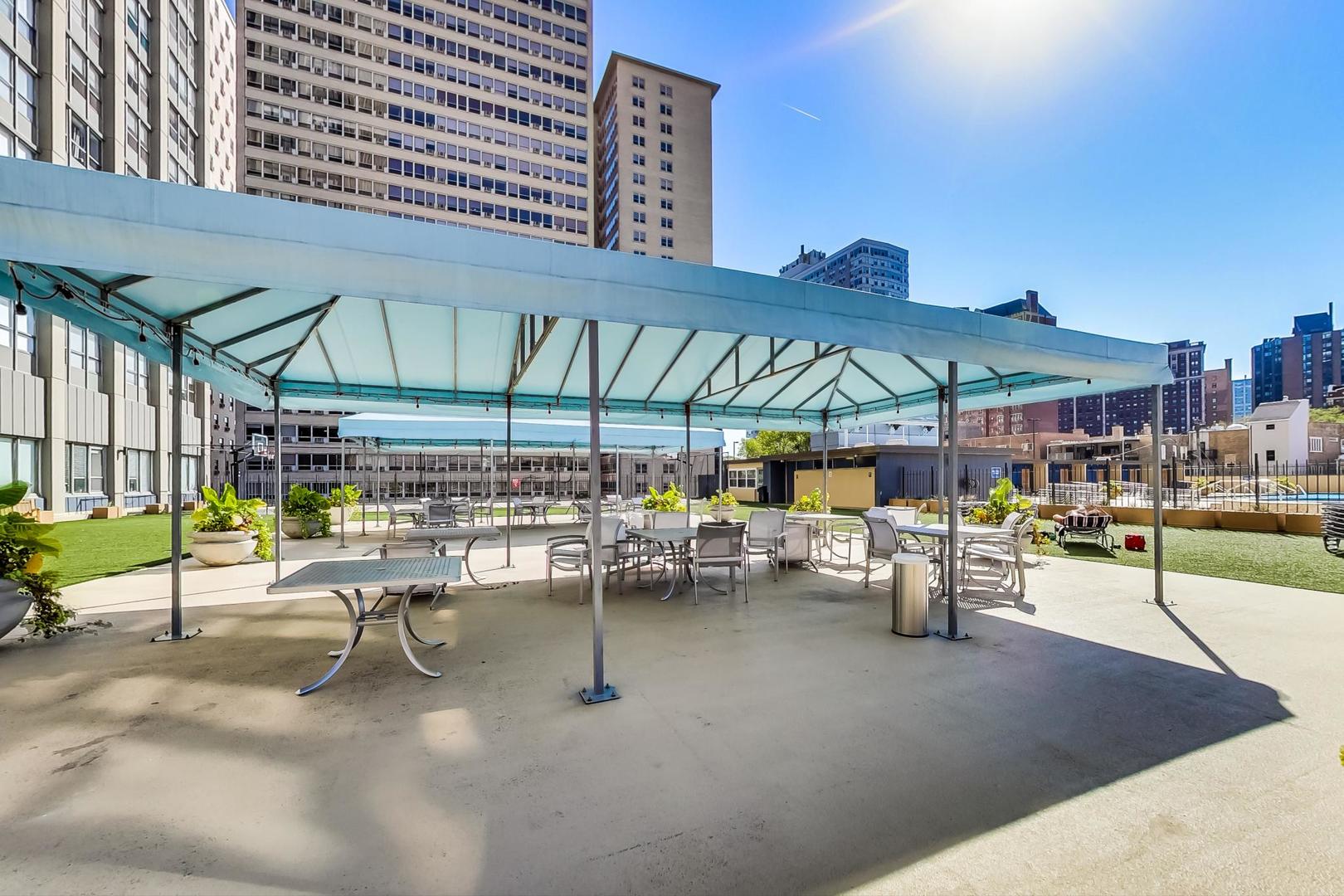 655 West Irving Park Road, Unit 1403 Chicago, IL 60613 - Photo 29 of 36 a view of a patio with a table and chairs under an umbrella