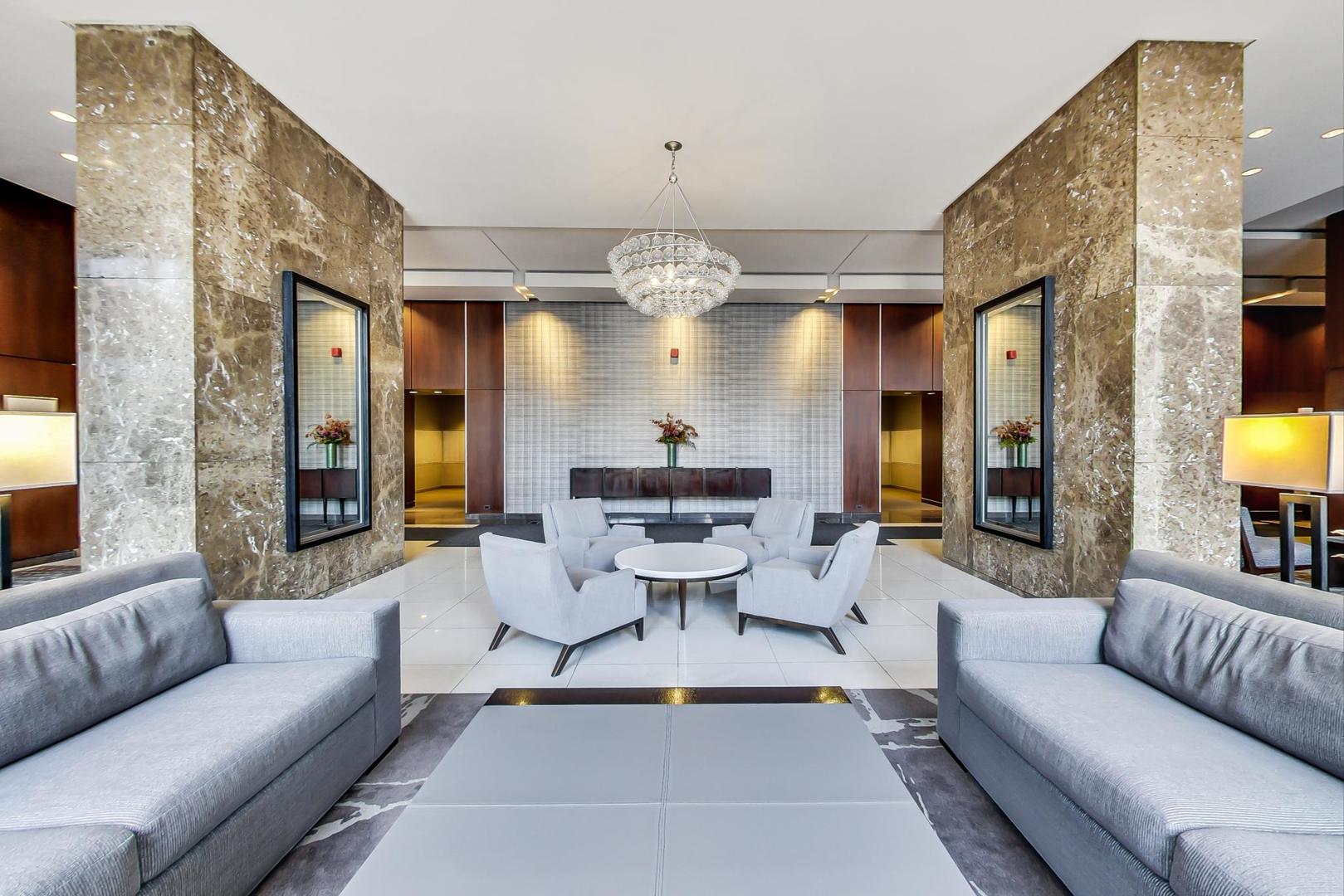 655 West Irving Park Road, Unit 1403 Chicago, IL 60613 - Photo 4 of 36 a living room with furniture a chandelier and a large window