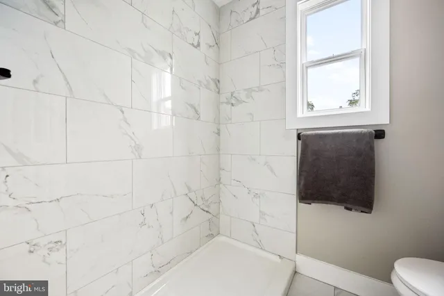 a bathroom with a toilet a bath tub and a window