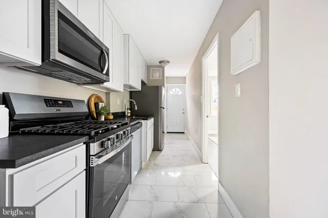 a kitchen with stainless steel appliances granite countertop a stove and a microwave