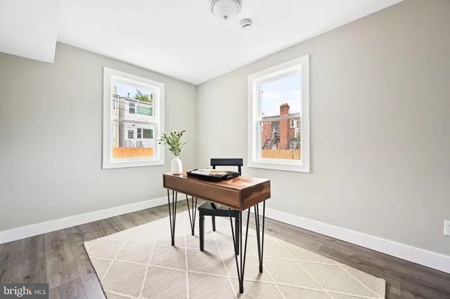 a view of a workspace with furniture and a window