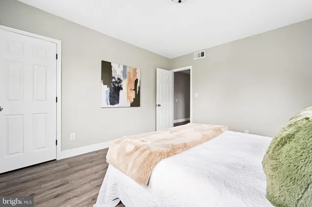 a bedroom with a bed and a painting on the wall