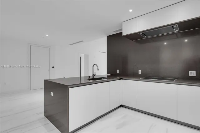 a kitchen with granite countertop a sink and cabinets