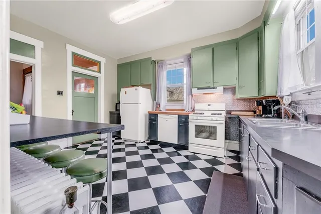 a kitchen with a checkered floor and white cabinets