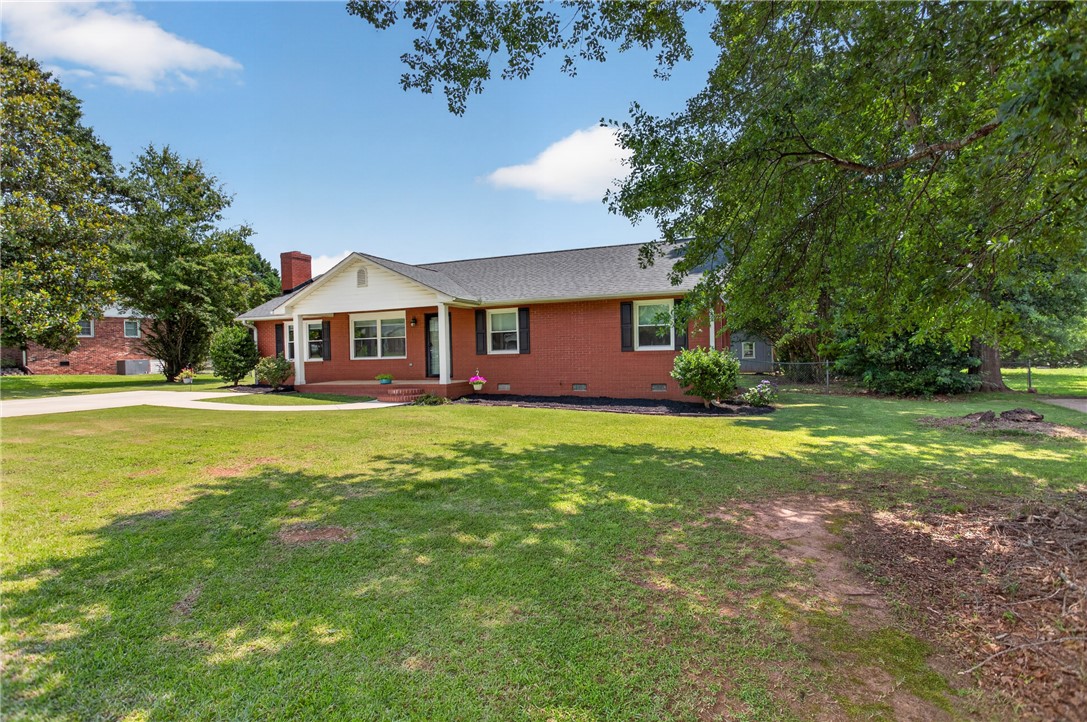 113 Greenfield Avenue Pendleton, SC 29670 - Photo 24 of 40 A classic brick exterior with a welcoming front porch and mature landscaping.