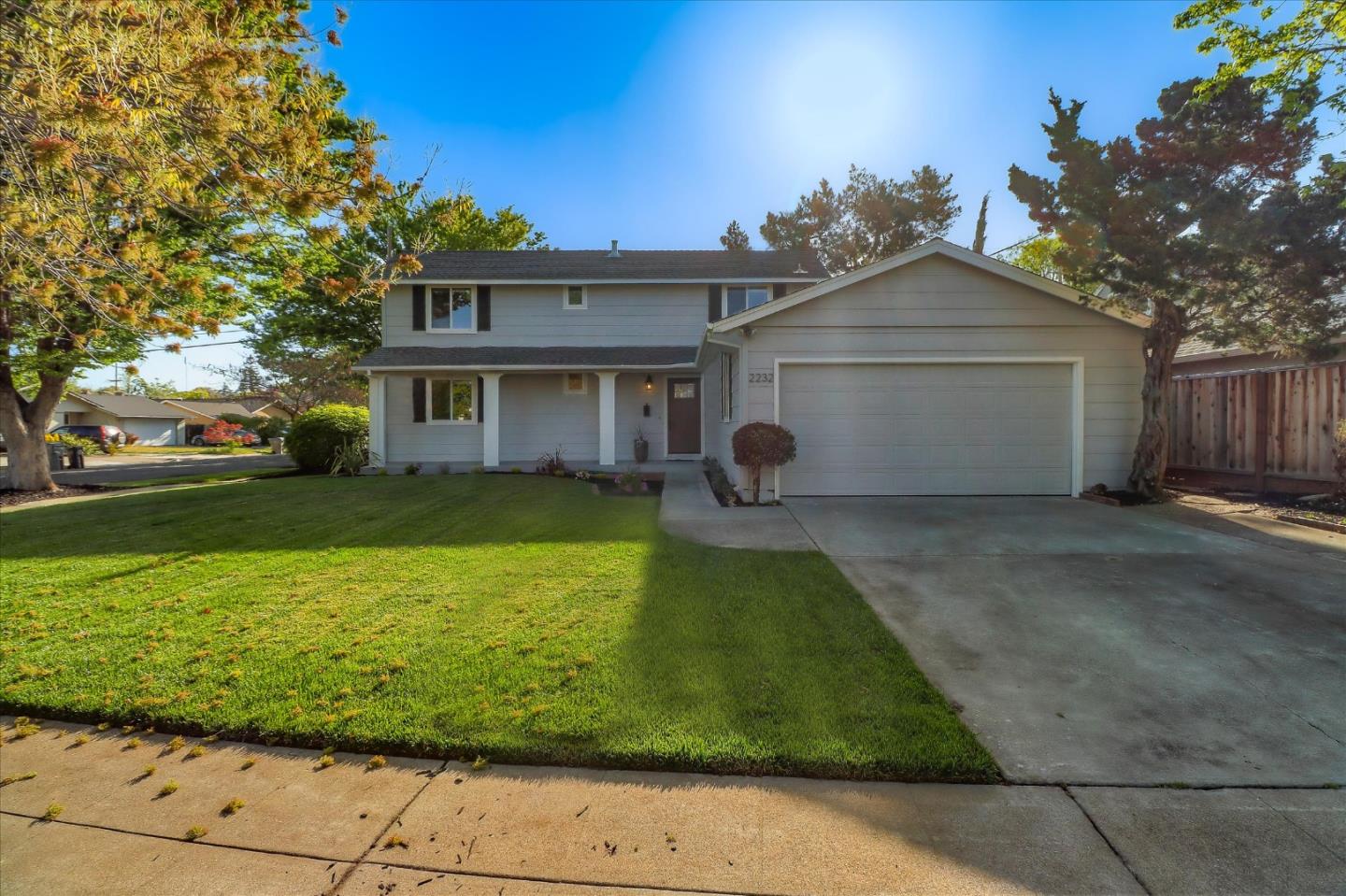 a front view of a house with a yard and potted plants