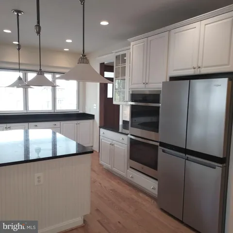 a kitchen with kitchen island a sink stove and wooden floor