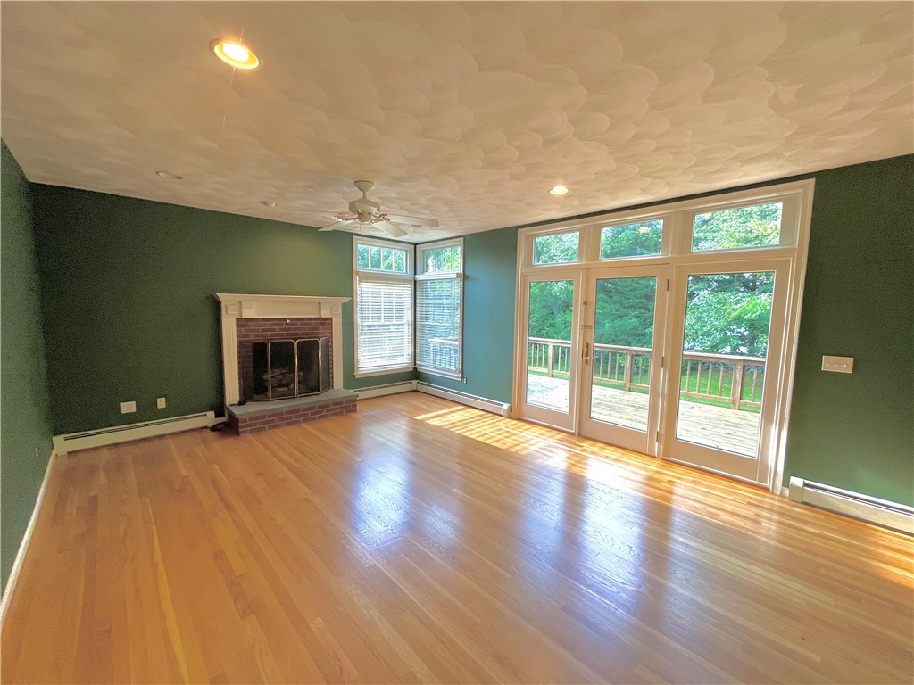 15 Jacobs Point Road Warren, RI 02885 - Photo 11 of 44 Large family room with gas fireplace with french door to enjoy the mature landscaped grounds.