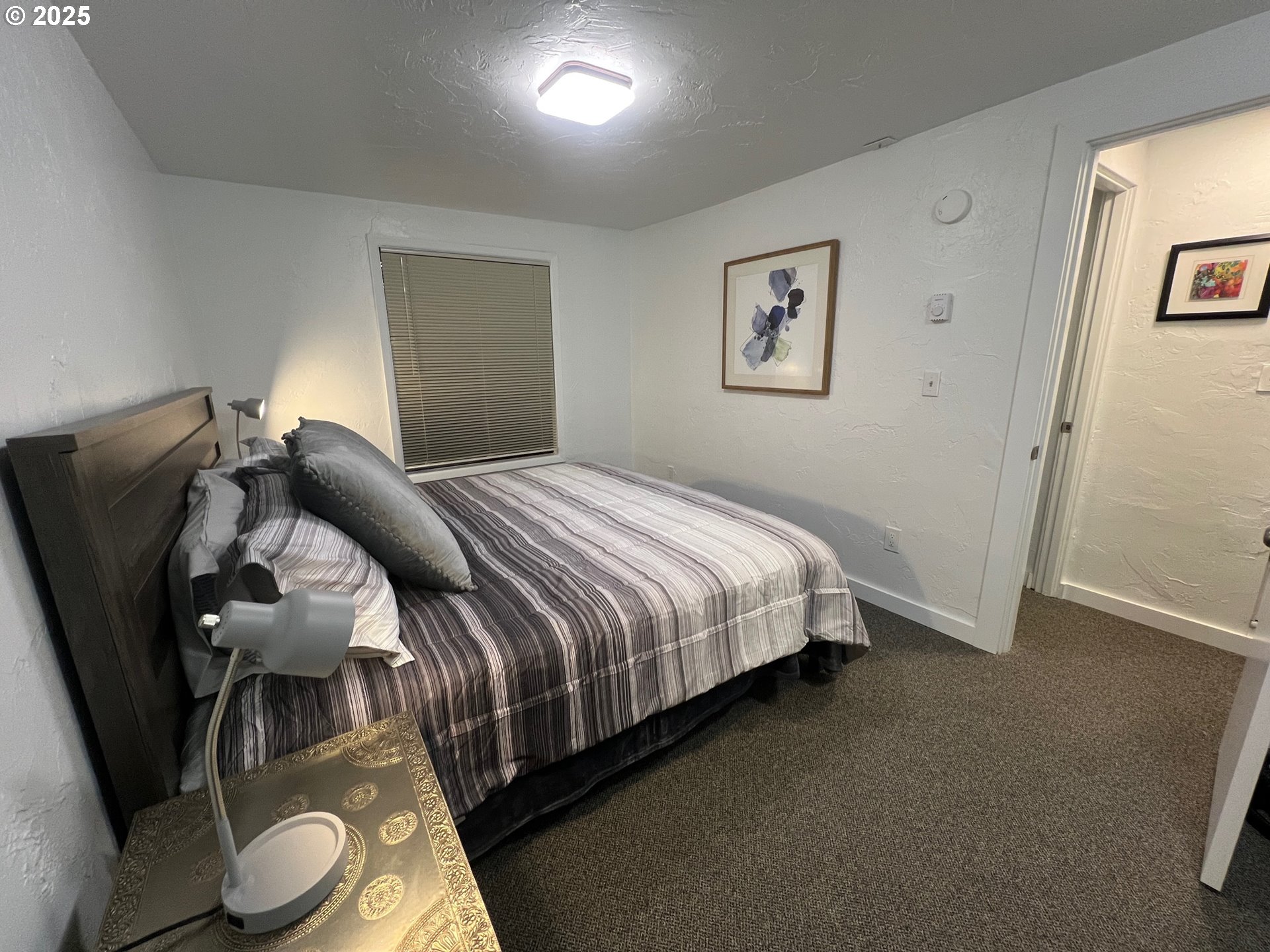 734 East 14th Avenue Eugene, OR 97401 - Photo 16 of 27 a bedroom with a bed and a painting on the wall