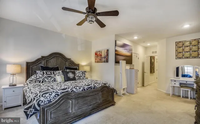 a bedroom with a bed a couch and a chandelier