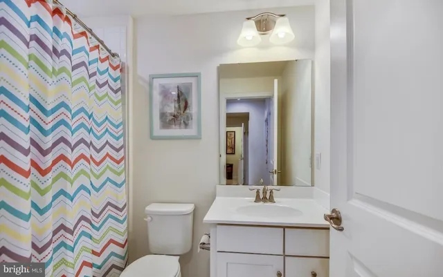 a bathroom with a sink mirror vanity and toilet