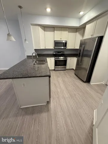 a kitchen with stainless steel appliances granite countertop a sink a stove top oven a counter space and cabinets