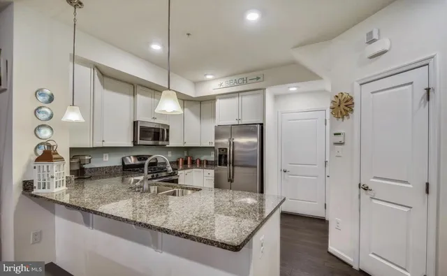 a kitchen with stainless steel appliances granite countertop a sink refrigerator and cabinets