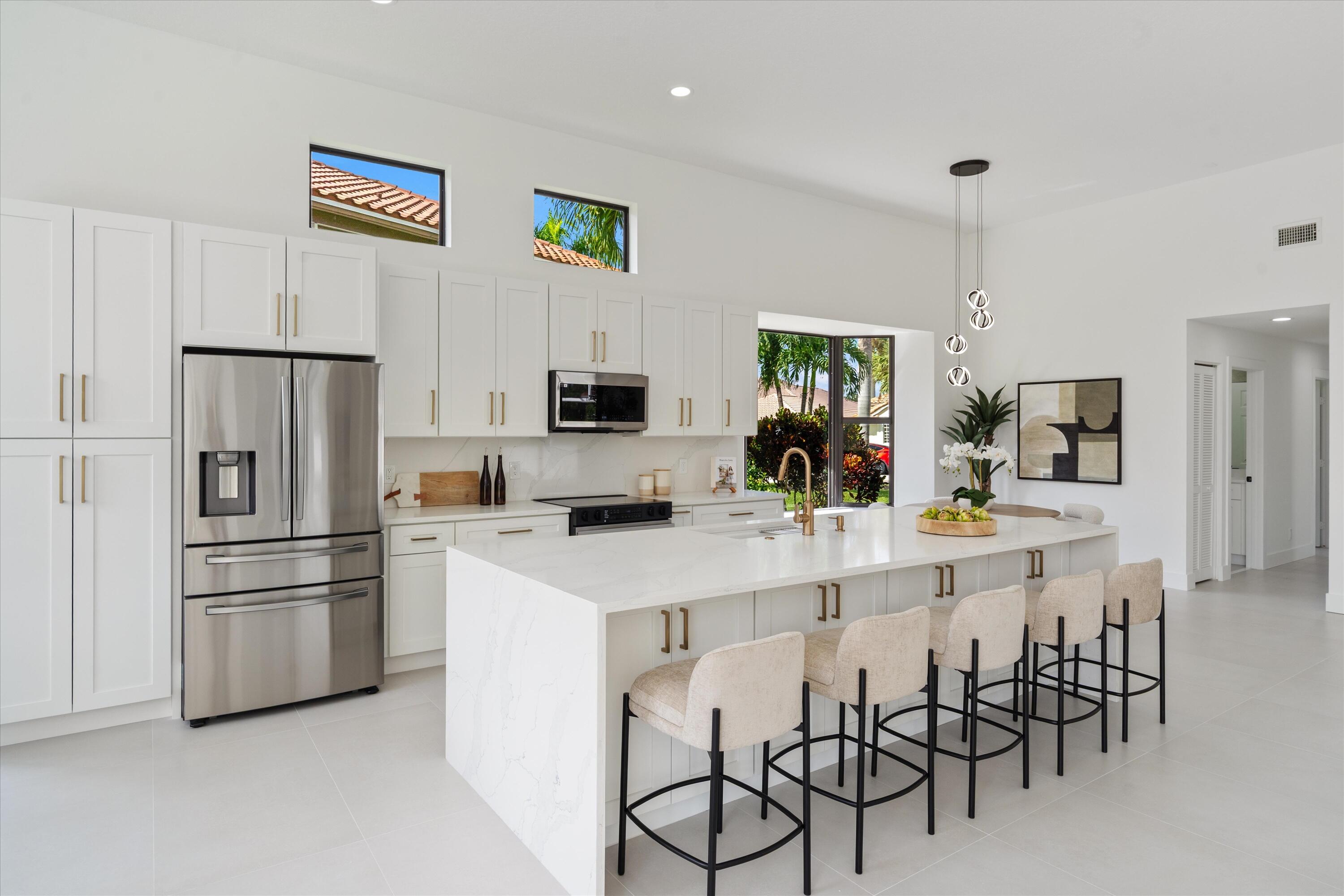 20209 Ocean Key Drive Boca Raton, FL 33498 - Photo 7 of 38 a kitchen with kitchen island white cabinets and stainless steel appliances
