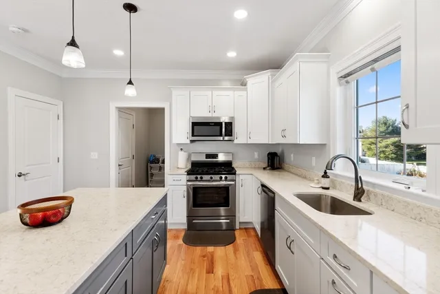 a kitchen with stainless steel appliances granite countertop a sink a stove and a refrigerator