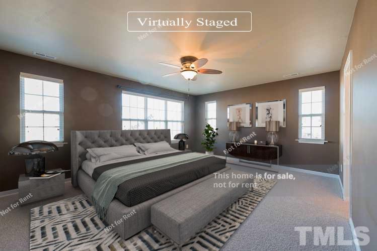9801 Layla Avenue Raleigh, NC 27617 - Photo 3 of 17 a spacious bedroom with a bed a couch and a window