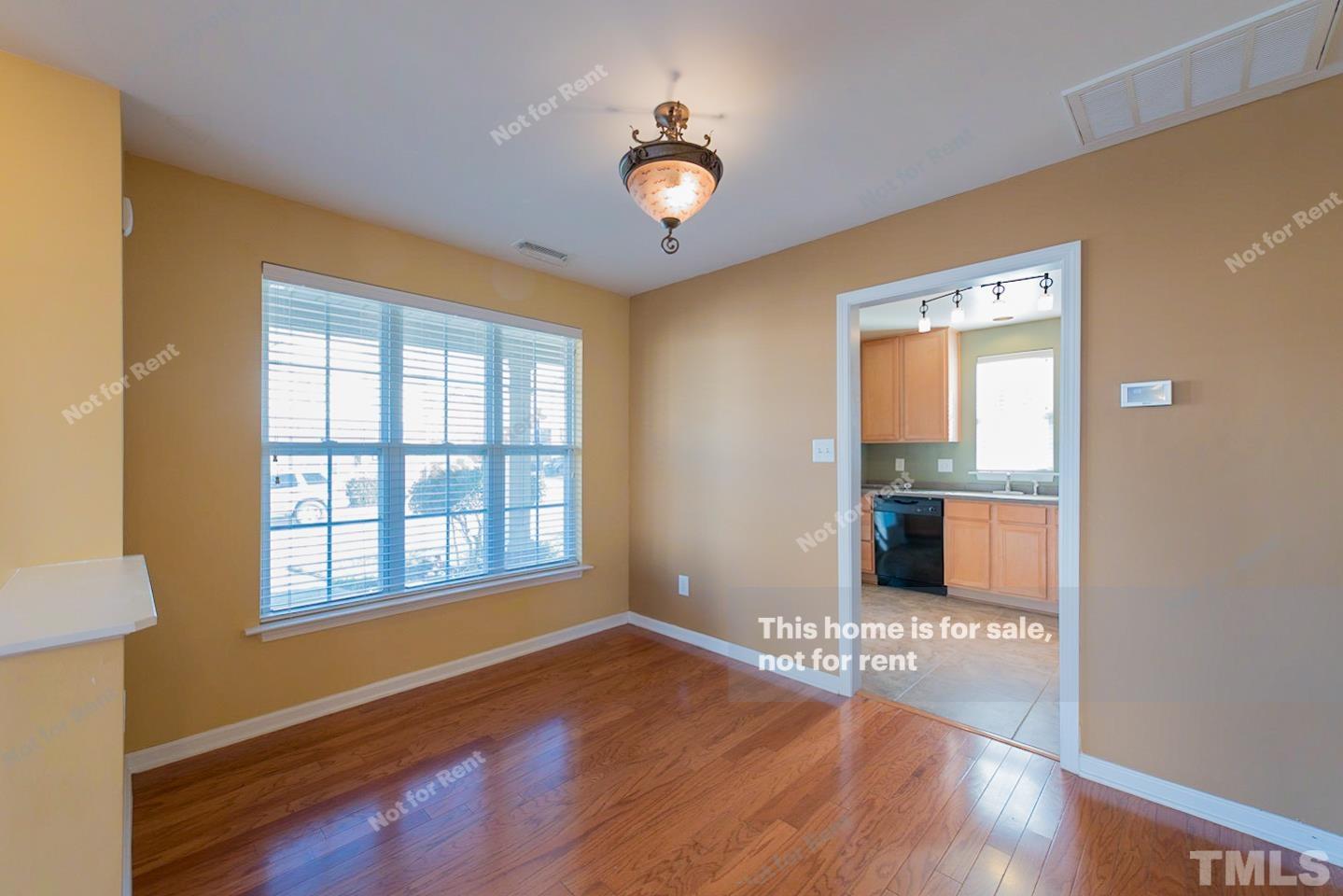 9801 Layla Avenue Raleigh, NC 27617 - Photo 10 of 17 a view of an empty room with a window and wooden floor