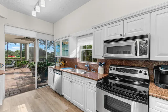 a kitchen with stainless steel appliances a stove a sink and a microwave