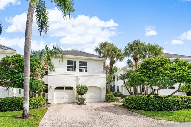 a front view of a house with a garden and yard