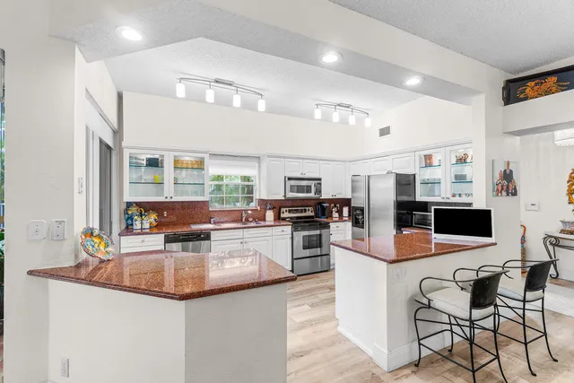 a kitchen with stainless steel appliances granite countertop a sink and a refrigerator