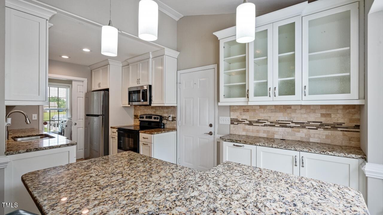 1065 Smith Road Smithfield, NC 27577 - Photo 11 of 36 a kitchen with a stove a sink and a refrigerator