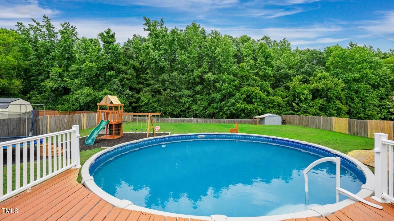 1065 Smith Road Smithfield, NC 27577 - Photo 30 of 36 a view of a swimming pool with a porch and a yard