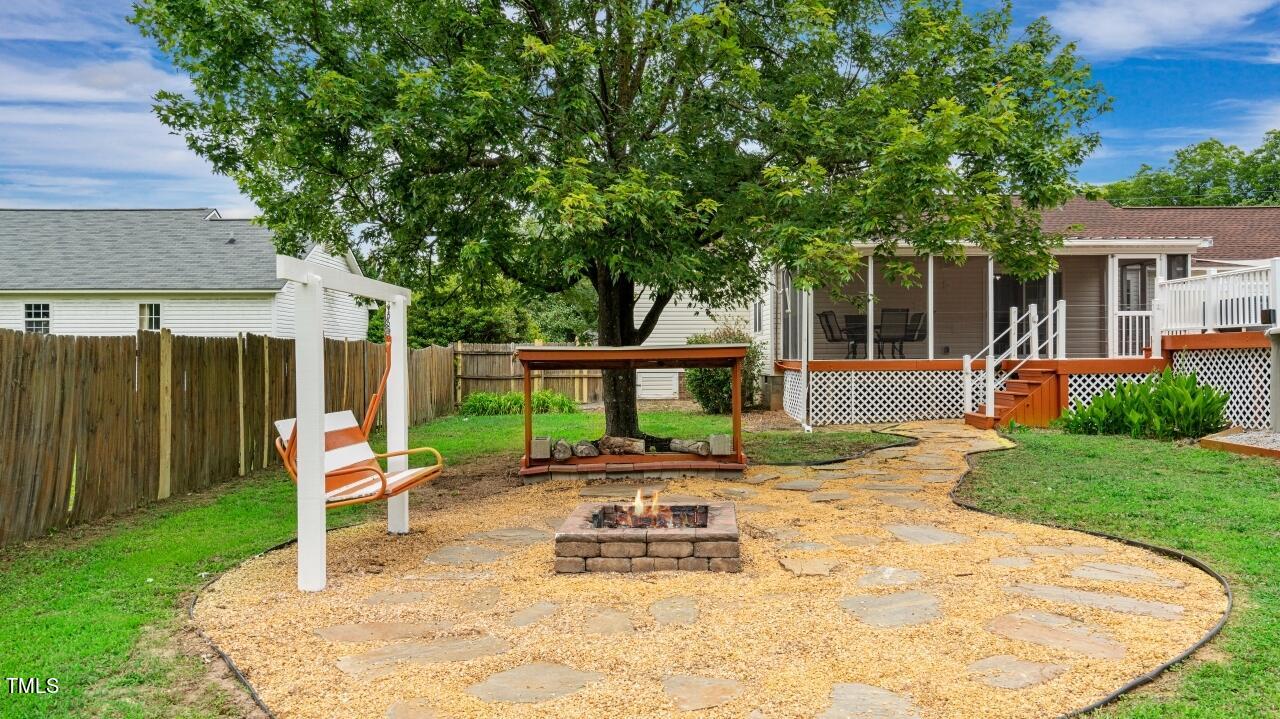 1065 Smith Road Smithfield, NC 27577 - Photo 4 of 36 a view of a backyard with table and chairs and a barbeque with wooden fence