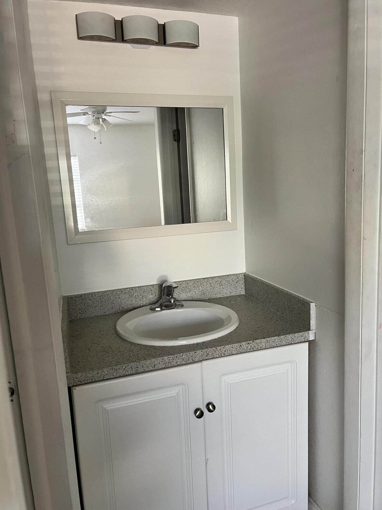 632 Northwest 13th Street, Unit 210 Boca Raton, FL 33486 - Photo 12 of 19 a bathroom with a granite countertop sink and a mirror