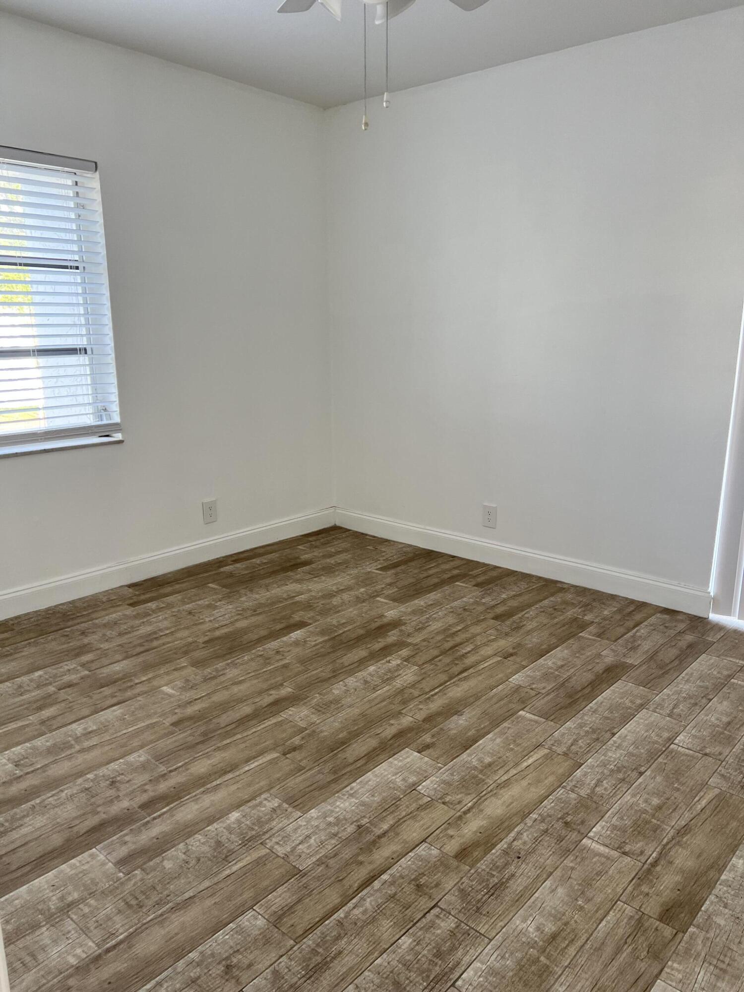 632 Northwest 13th Street, Unit 210 Boca Raton, FL 33486 - Photo 13 of 19 an empty room with wooden floor and windows