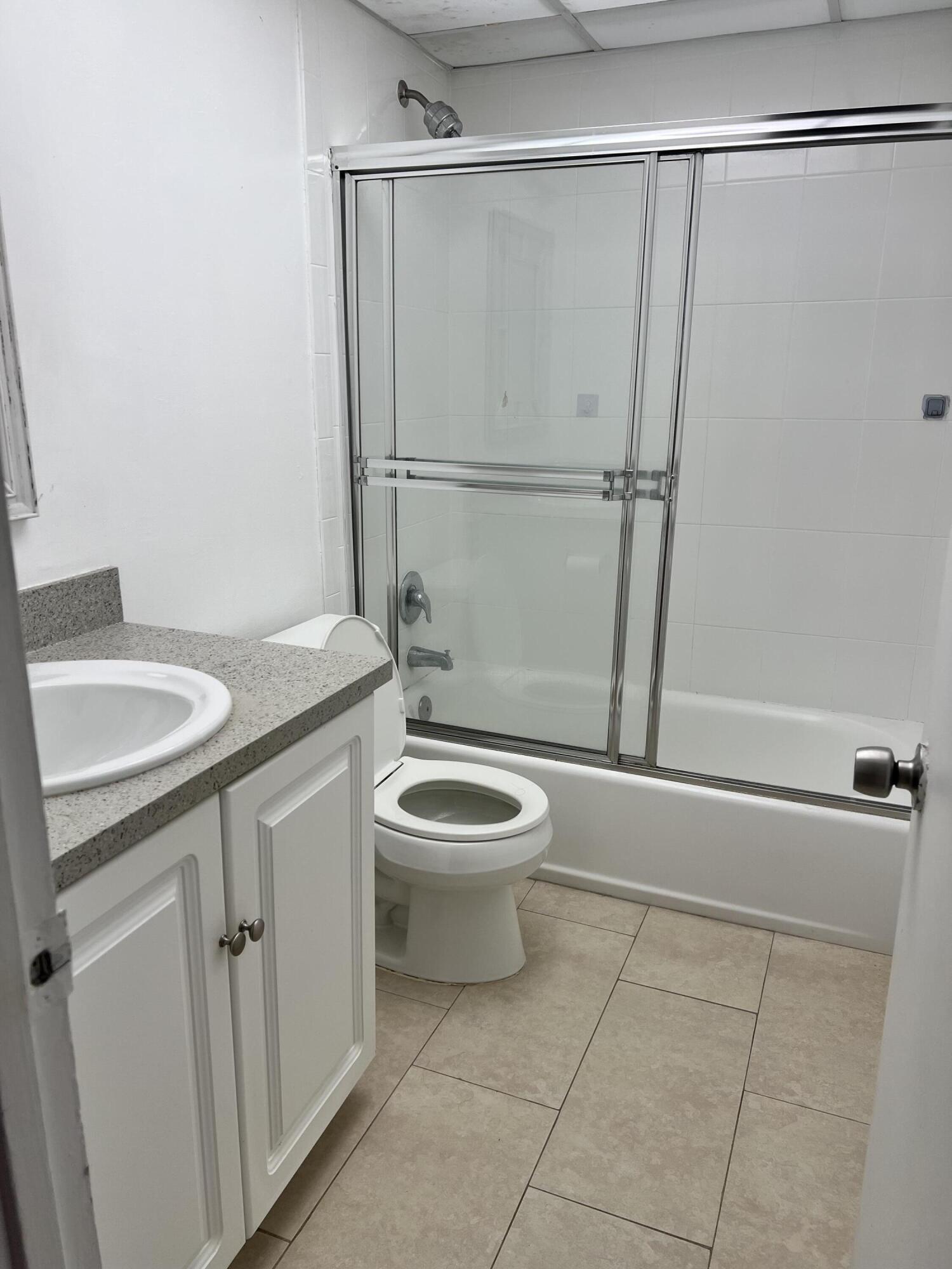 632 Northwest 13th Street, Unit 210 Boca Raton, FL 33486 - Photo 15 of 19 a bathroom with a granite countertop sink toilet and shower