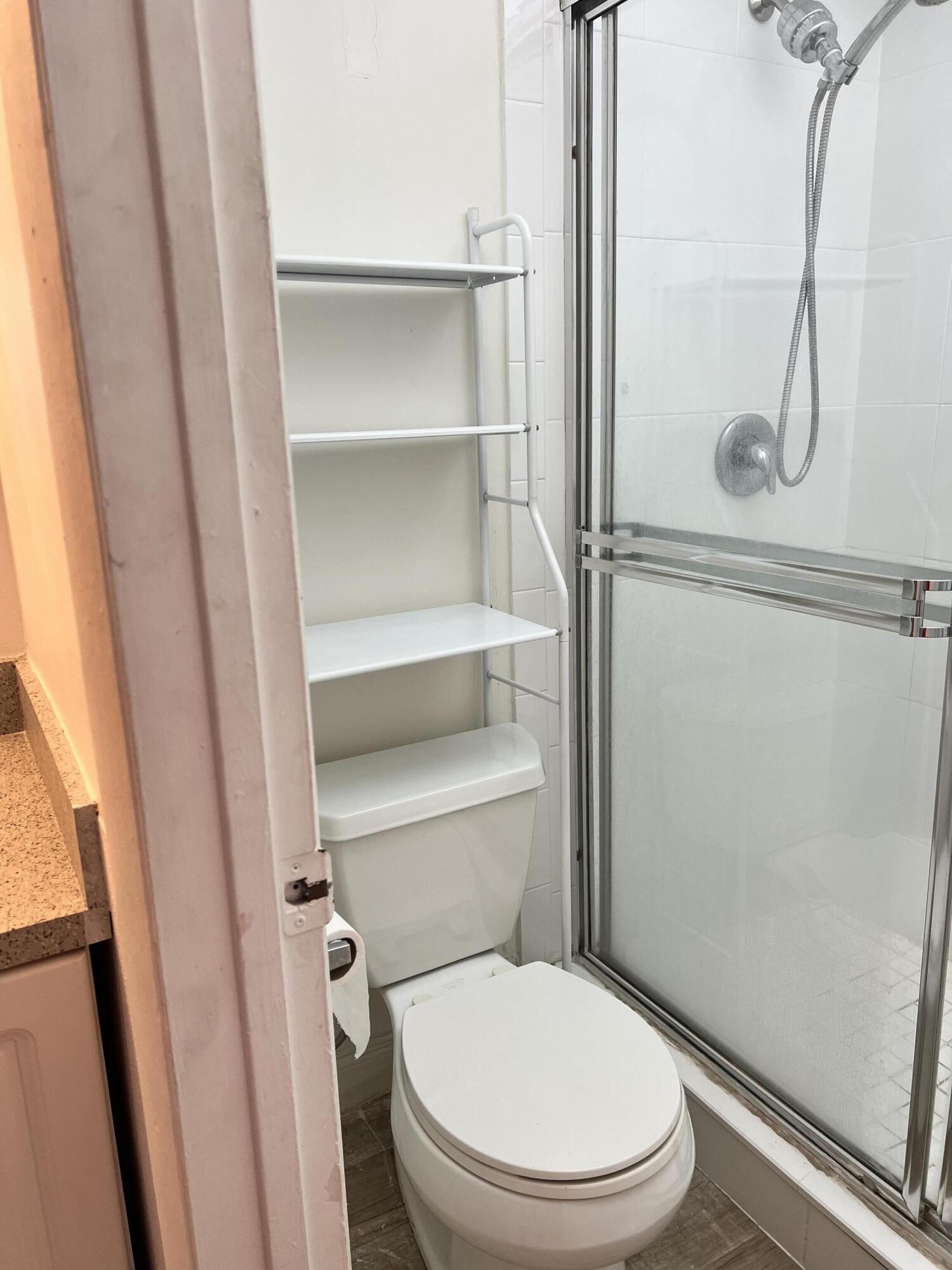 632 Northwest 13th Street, Unit 210 Boca Raton, FL 33486 - Photo 18 of 19 a white toilet sitting next to a shower