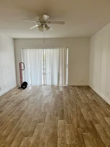 an empty room with a ceiling fan and window