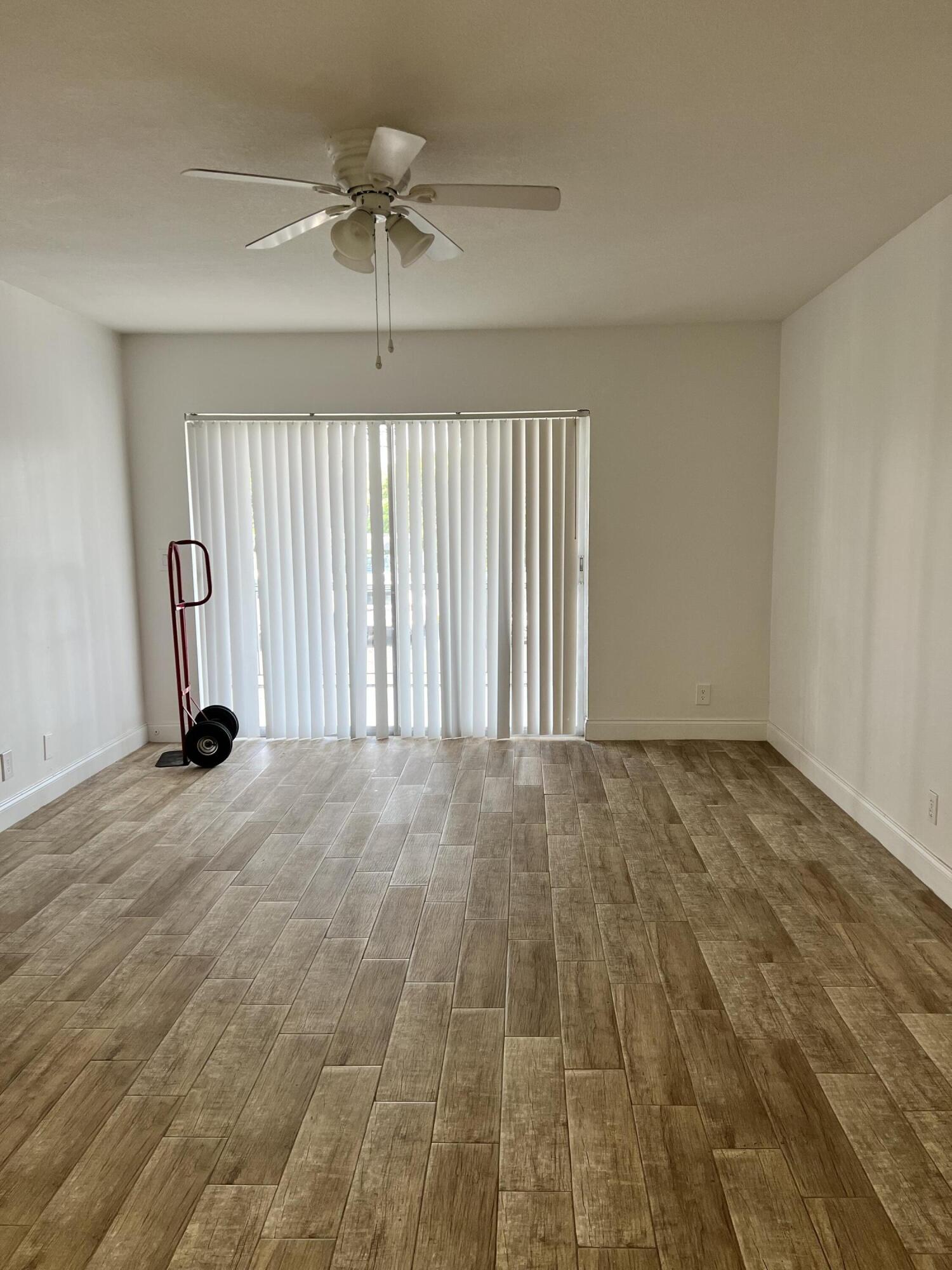 632 Northwest 13th Street, Unit 210 Boca Raton, FL 33486 - Photo 5 of 19 an empty room with a ceiling fan and window