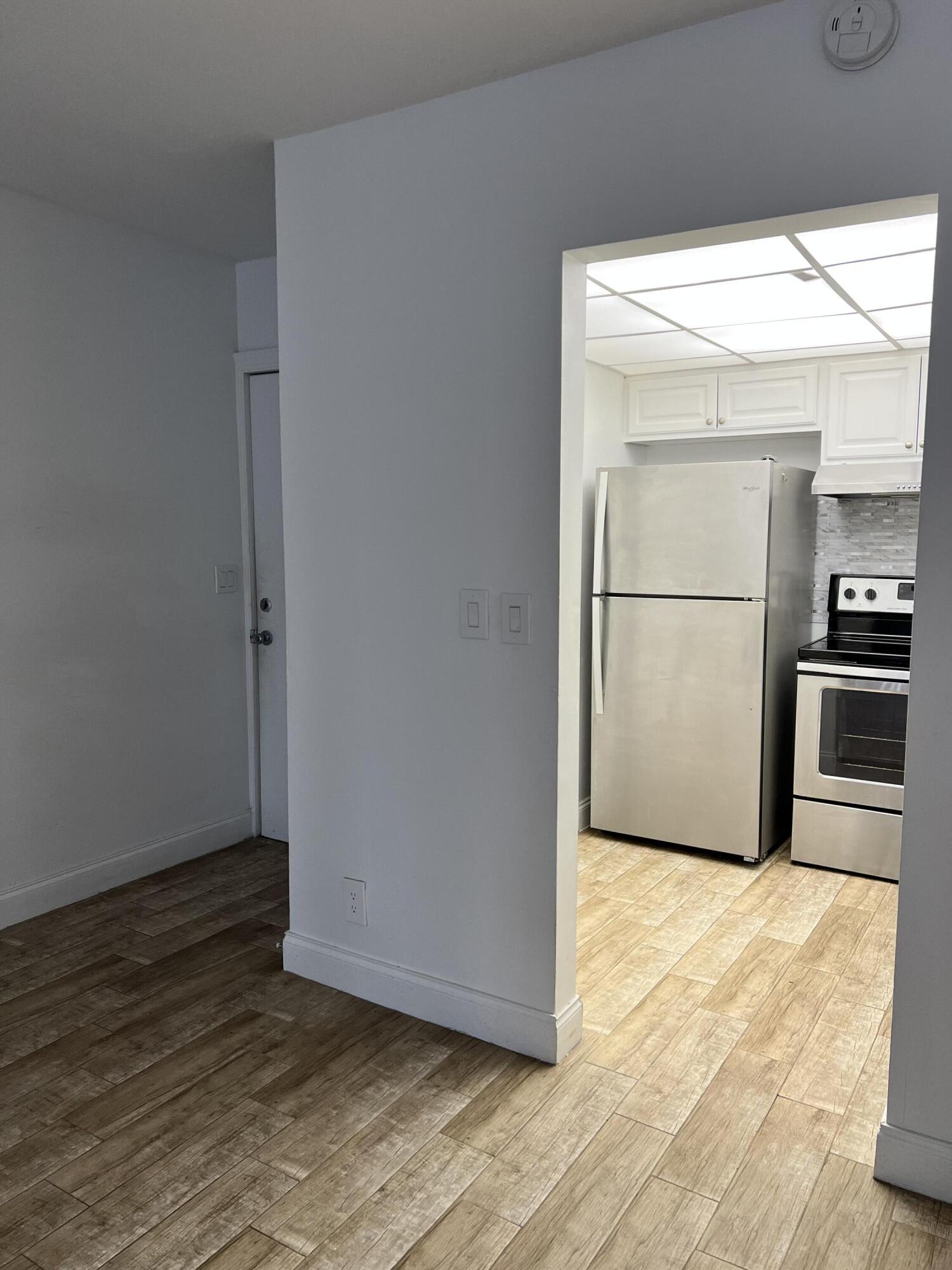 632 Northwest 13th Street, Unit 210 Boca Raton, FL 33486 - Photo 6 of 19 a view of a kitchen with wooden floor and electronic appliances