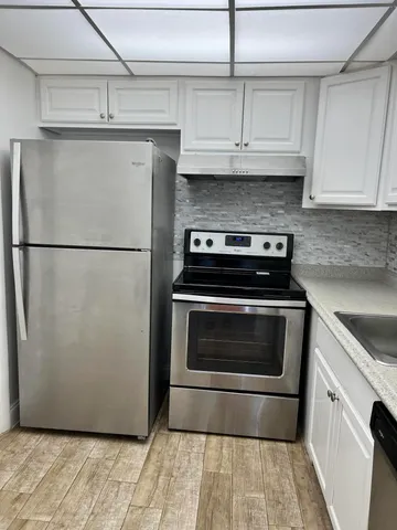 a kitchen with granite countertop a refrigerator and a stove