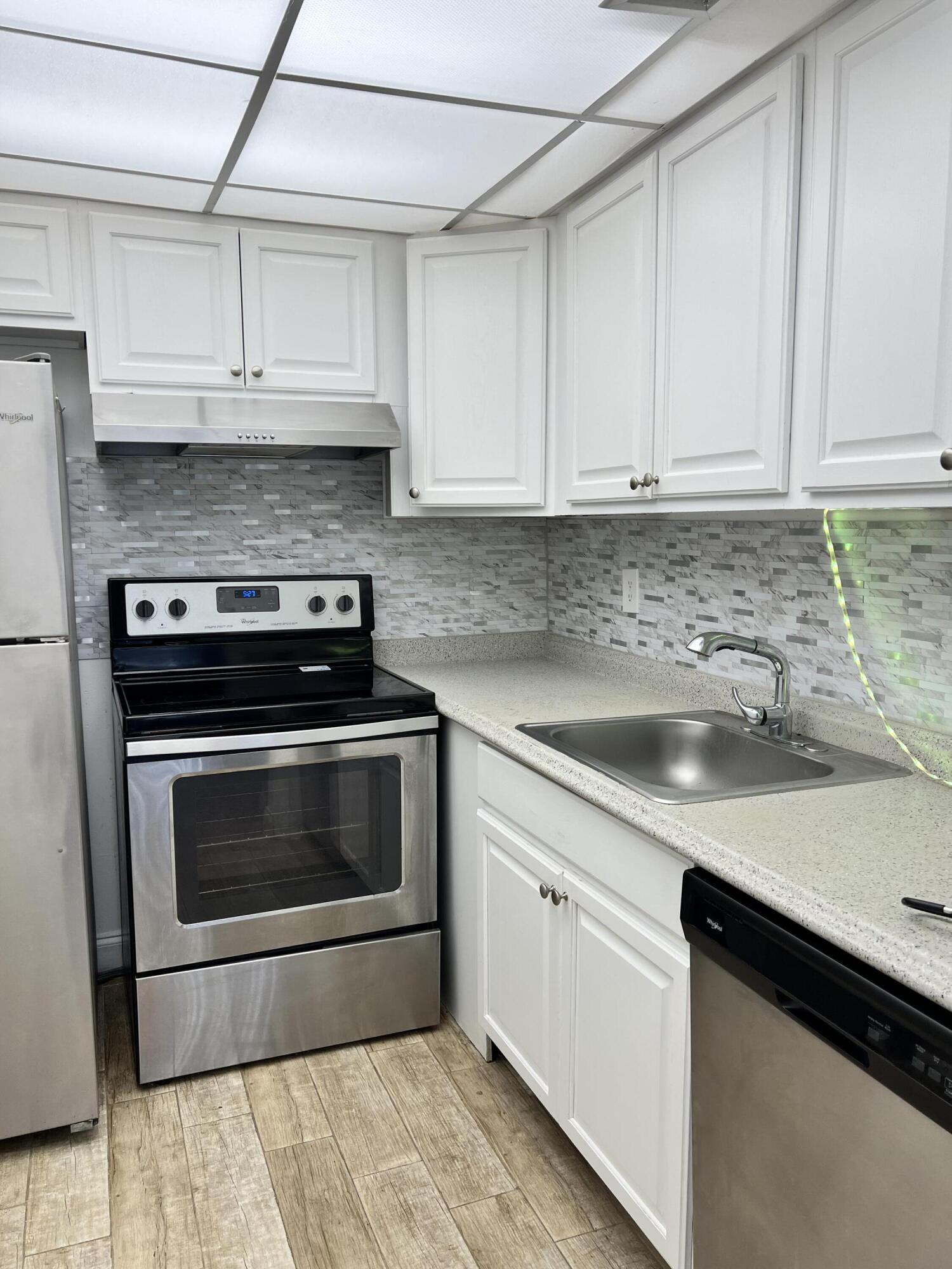 632 Northwest 13th Street, Unit 210 Boca Raton, FL 33486 - Photo 9 of 19 a kitchen with granite countertop white cabinets and stainless steel appliances
