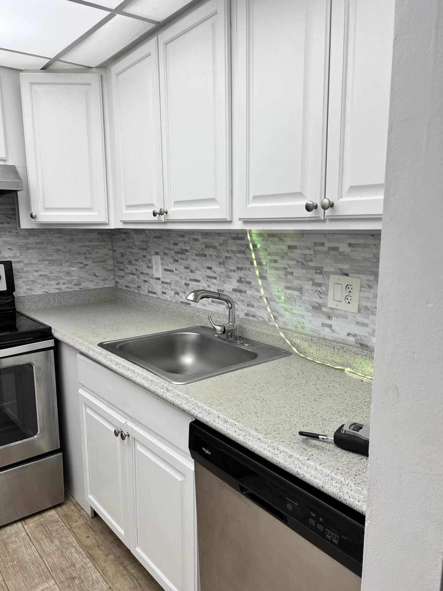 632 Northwest 13th Street, Unit 210 Boca Raton, FL 33486 - Photo 10 of 19 a kitchen with granite countertop white cabinets and sink