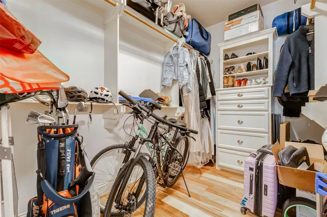 a view of walk in closet with clothes and shoes