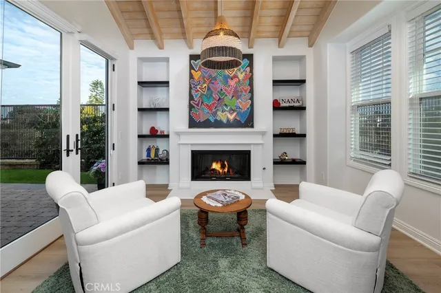 a living room with furniture a fireplace and a floor to ceiling window