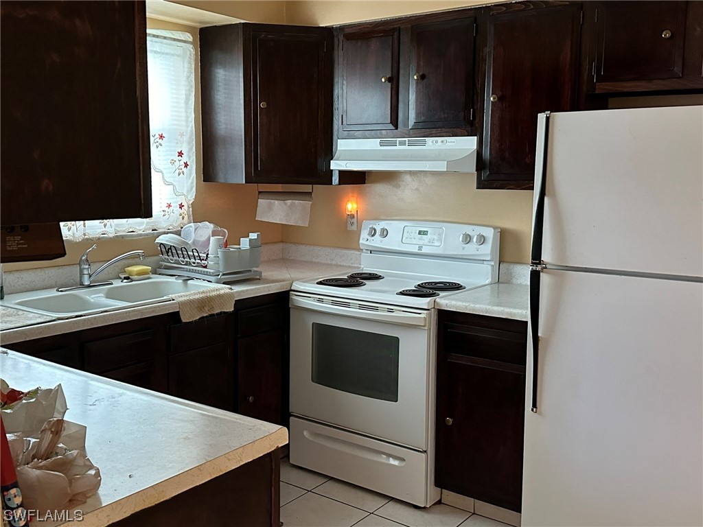 110 Florida Road Lehigh Acres, FL 33936 - Photo 3 of 10 a kitchen with stainless steel appliances granite countertop a sink stove and refrigerator