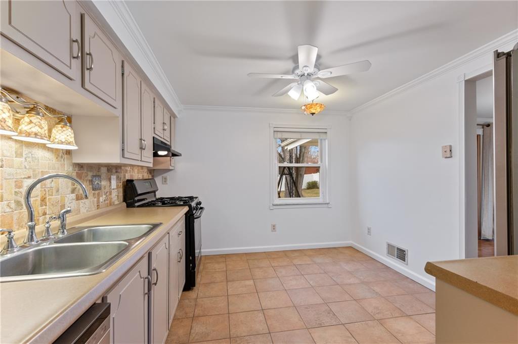 7 Dover Road Irwin, PA 15642 - Photo 12 of 31 a kitchen with a sink a stove cabinets and a window