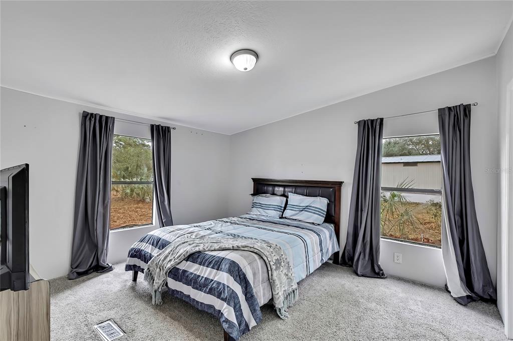 15739 Brenda Street Hudson, FL 34667 - Photo 16 of 50 a bedroom with a bed and a window