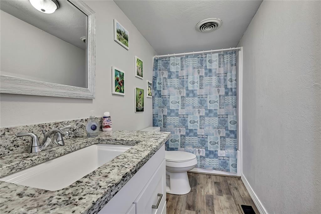 15739 Brenda Street Hudson, FL 34667 - Photo 24 of 50 a bathroom with a granite countertop sink a toilet and a bathtub
