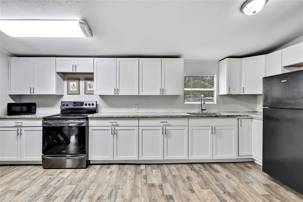 15739 Brenda Street Hudson, FL 34667 - Photo 9 of 50 a kitchen with stainless steel appliances granite countertop a stove a sink dishwasher and a refrigerator