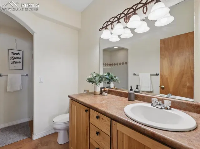 a bathroom with a granite countertop sink a toilet and a mirror